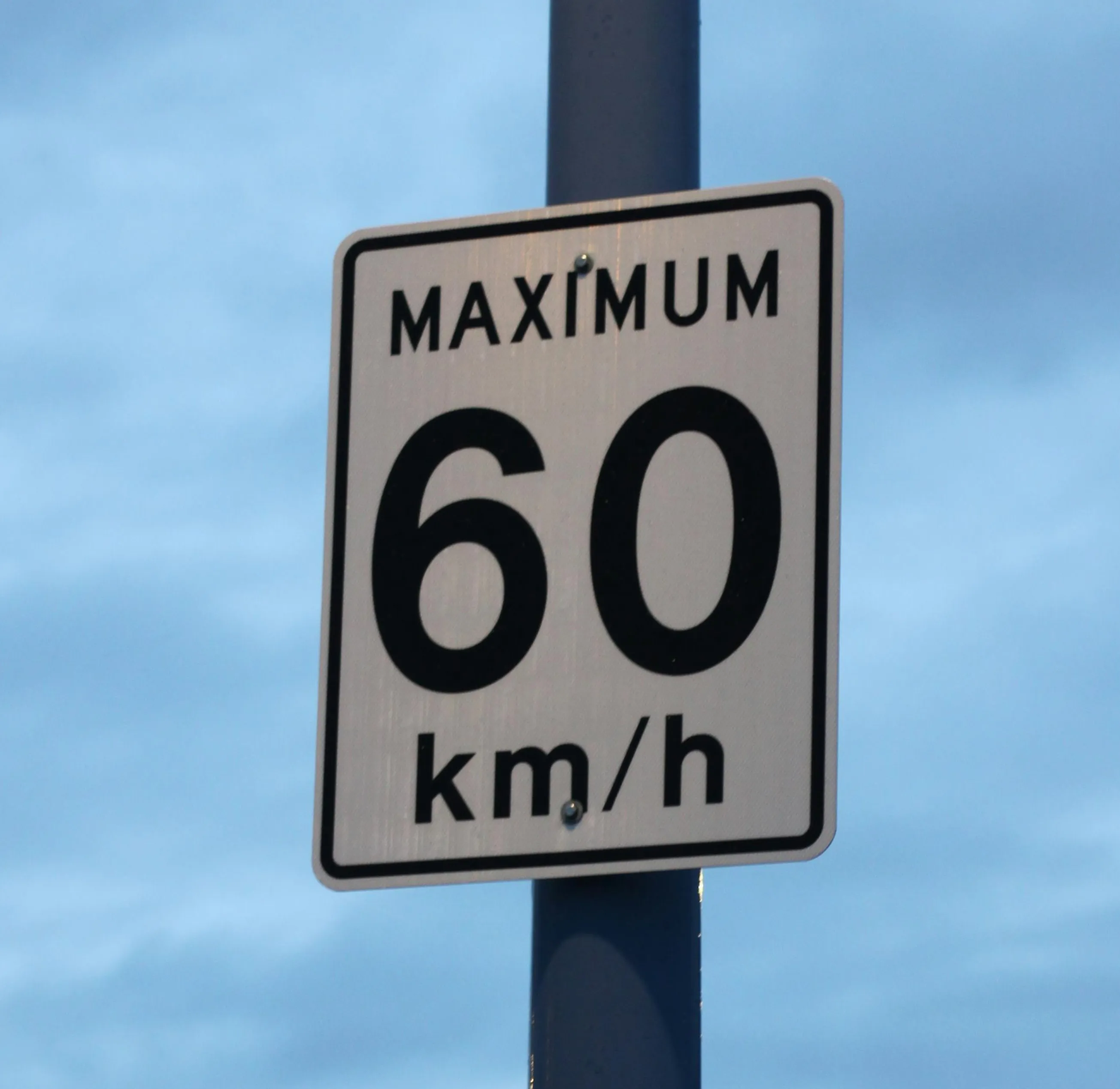 A close up of a street sign with a sky background.